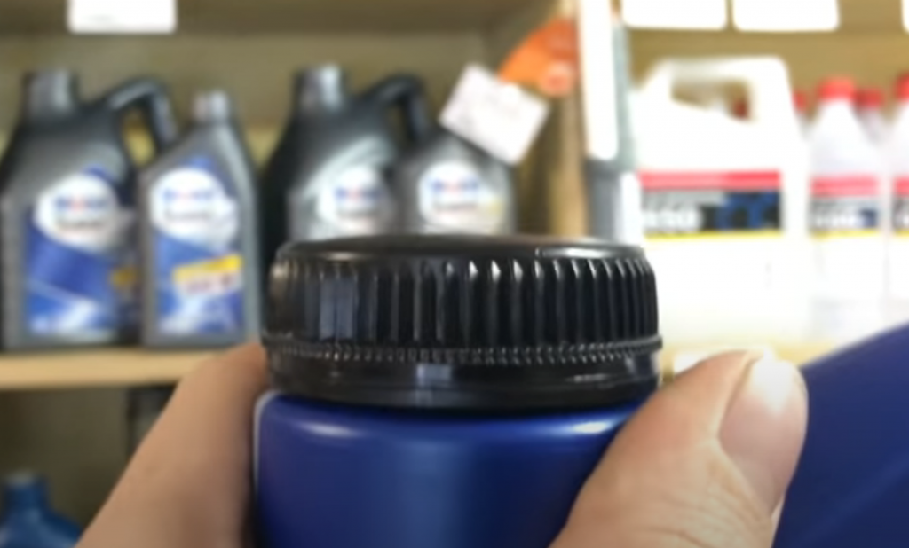 Крышка оригинального контейнера ELF слегка выпуклая, между ней и горлышком имеется зазор Крышка оригинального контейнера ELF слегка выпуклая